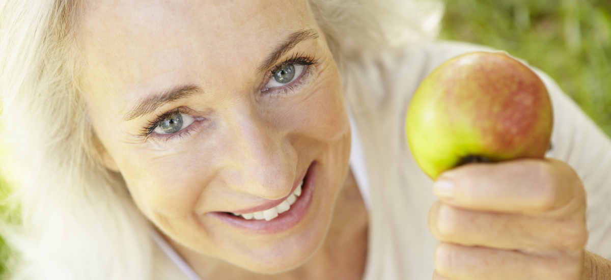 Senior woman eating apple outdoors